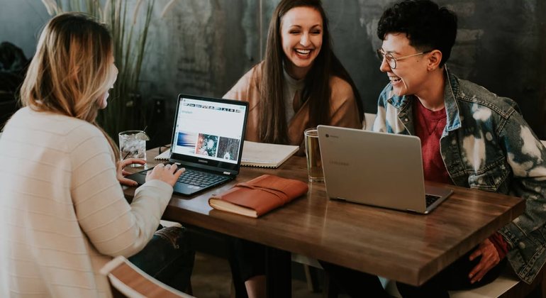 Three professionals discussing a dashboard during an intro meeting.